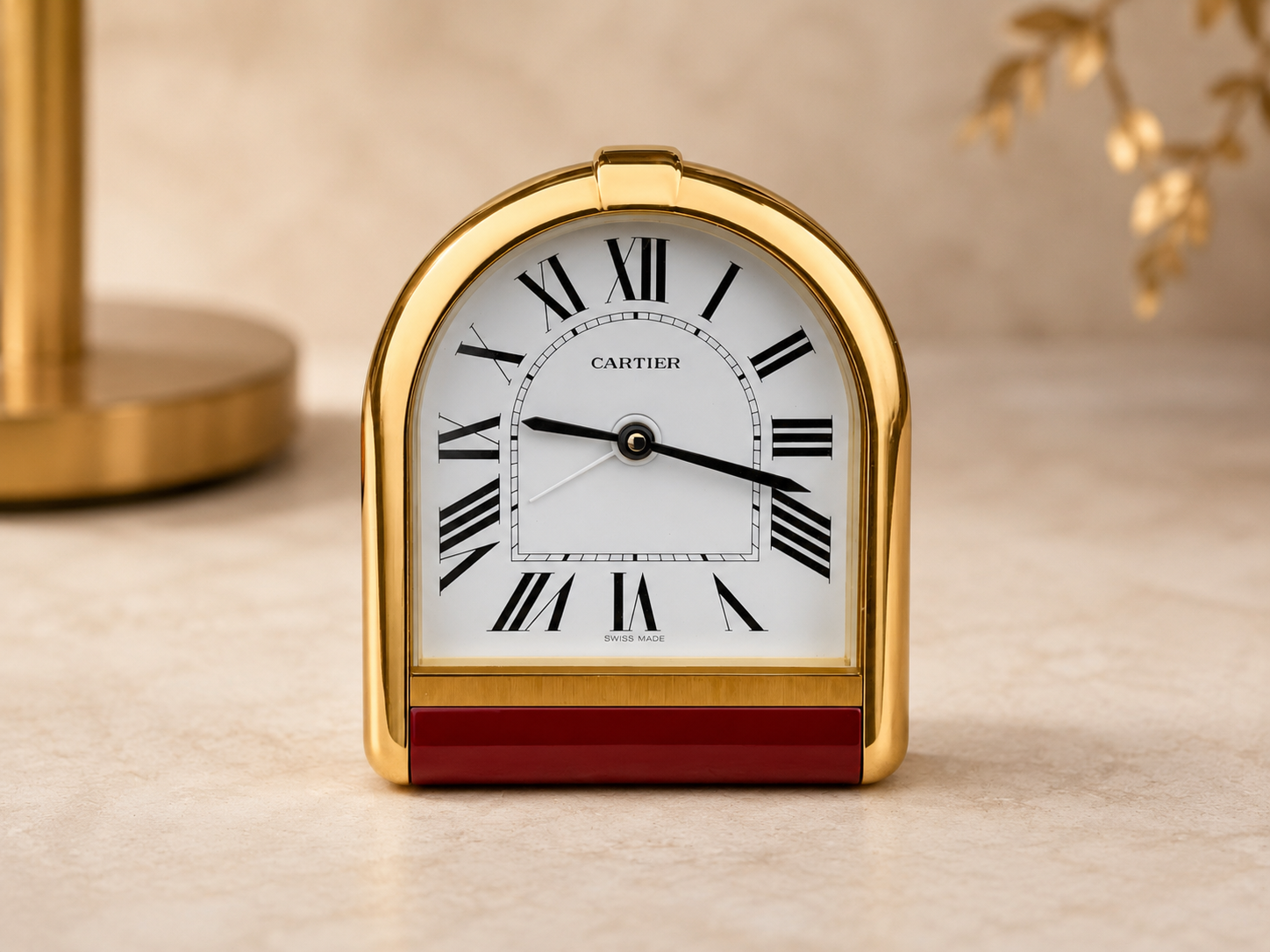 Cartier Romane Pendulette desk and travel clock, frontal view of the gold-tone case with burgundy lacquer base
