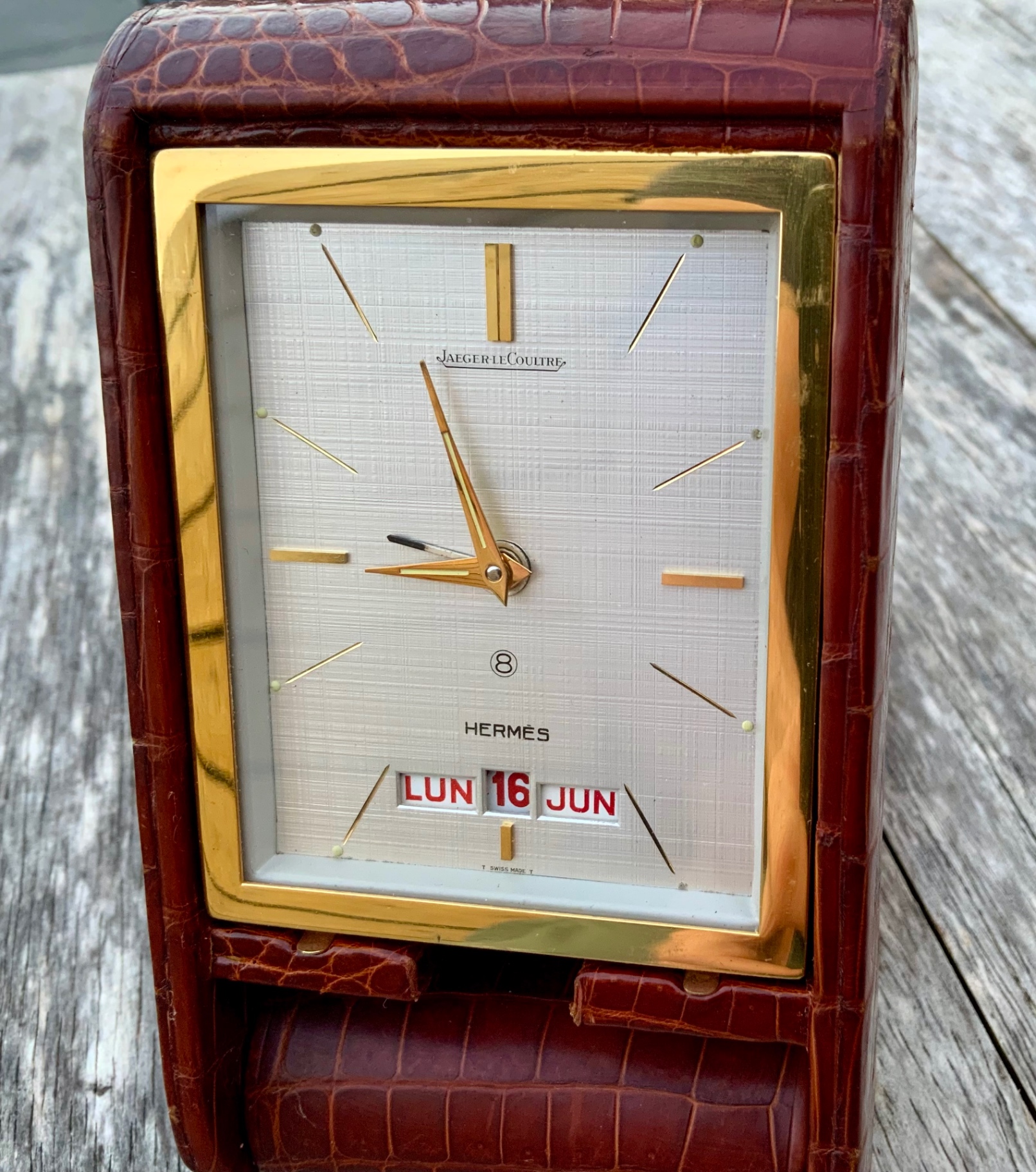 Jaeger-LeCoultre Ados Triple Calendar Travel Clock retailed by Hermès, frontal view in burgundy crocodile leather case