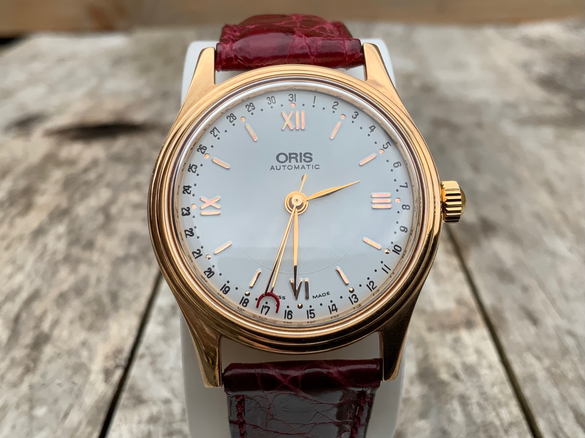 Oris Pointer Date 18K Rose Gold, frontal view of white dial with red crescent date pointer