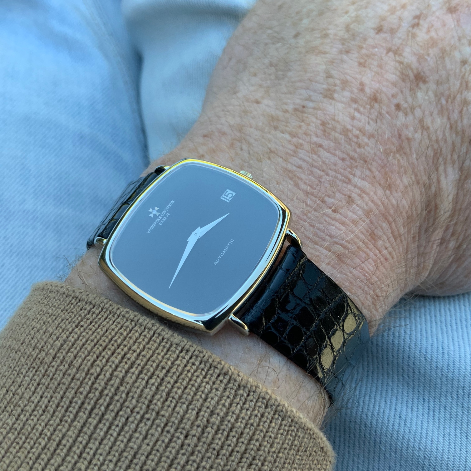 Vacheron Constantin cushion case worn on the wrist over blue denim