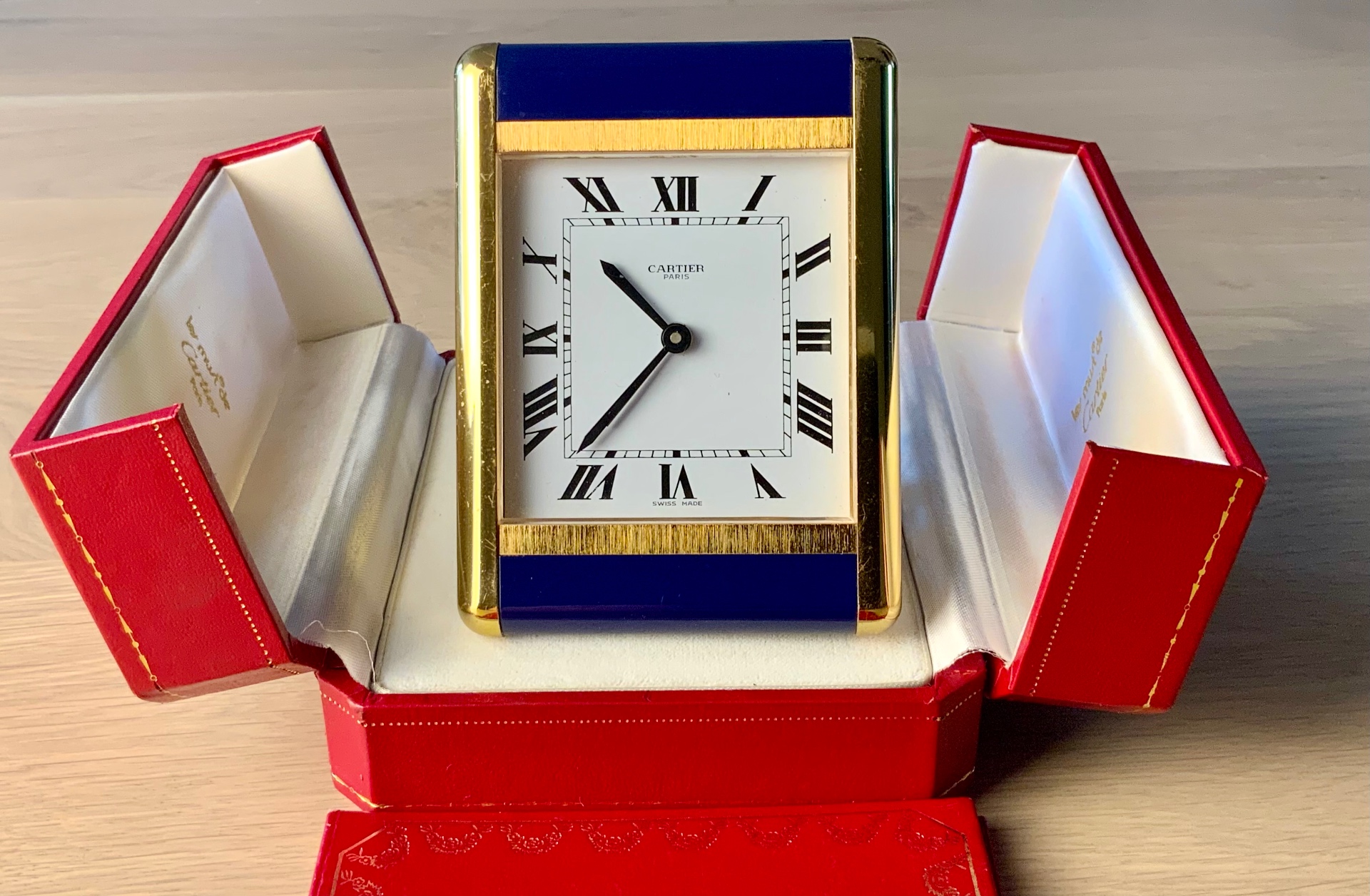 Cartier Tank Travel Alarm Clock Ref. 7505 shown frontally within its open red Cartier presentation box
